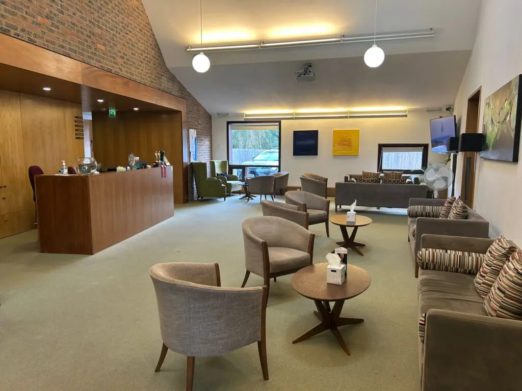 Vision Clinic waiting area with brown sofas and chairs and reception desk
