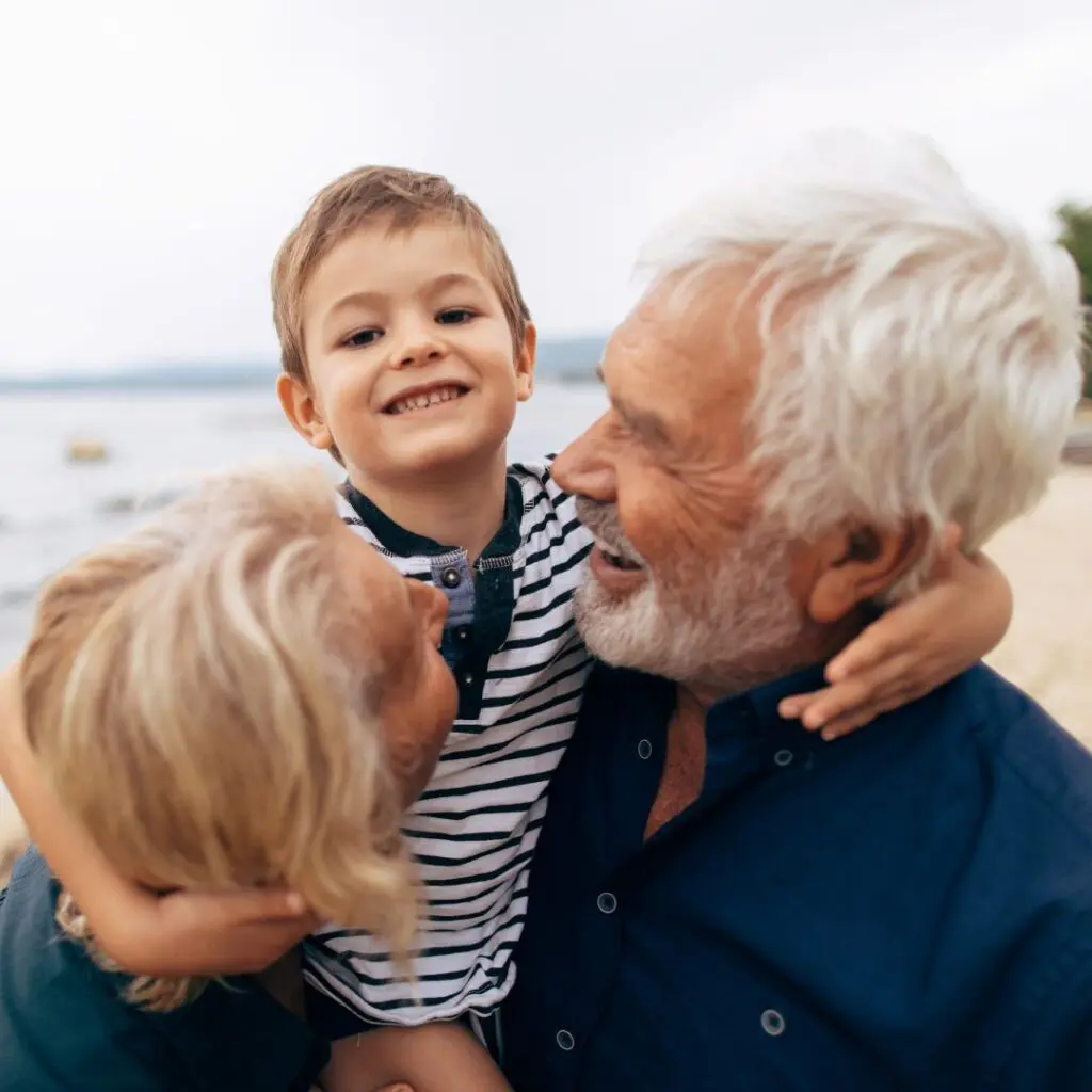 elderly couple enjoying time with grandchild on beach seeing clearly after cataract eye surgery