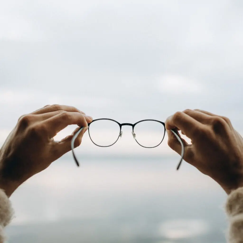 Centre for Sight pair of glasses being held looking out to sea - eye prescription