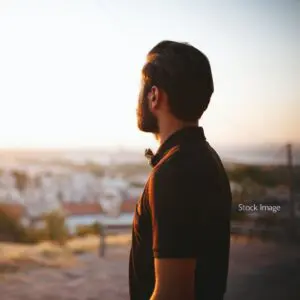 Man looking out at view in t shirt dark hair