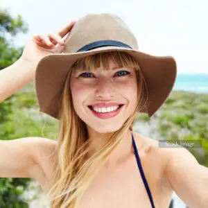 Centre for Sight patient story stock image lady in hat taking selfie in the sun on holiday straw hat