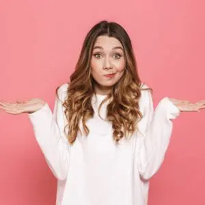 Centre for Sight Young Lady Shrugging pink background pursed lips to the side confused