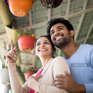 Young couple outside hugging wearing pink and pale blue smiling
