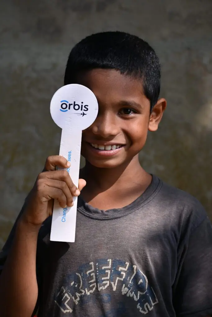 Child holding Orbis Eye Paddle