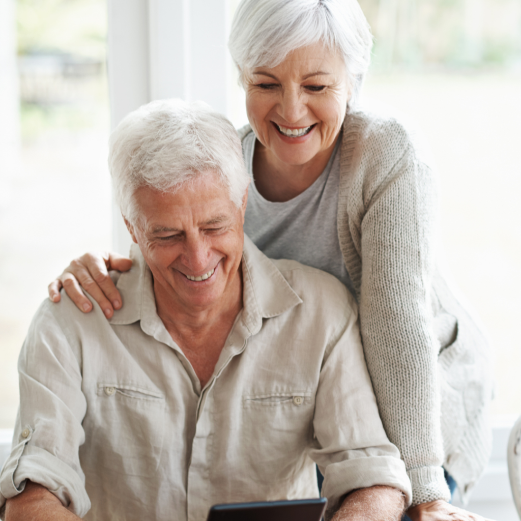 Elderly Man and Lady Looking at Laptop Screen Smiling Choosing Cataract Eye Surgery