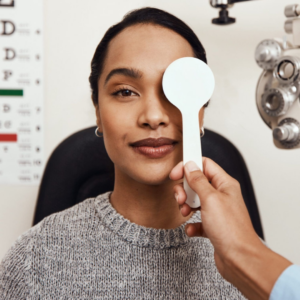 Lady having her eyes tested with an optician wearing grey jumper