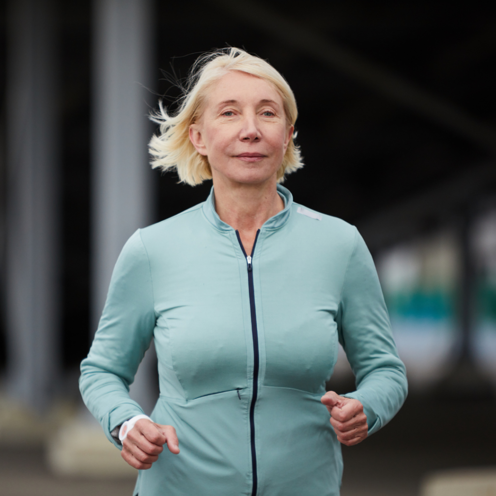 Blonde lady with short hair wearing blue jacket running through streets