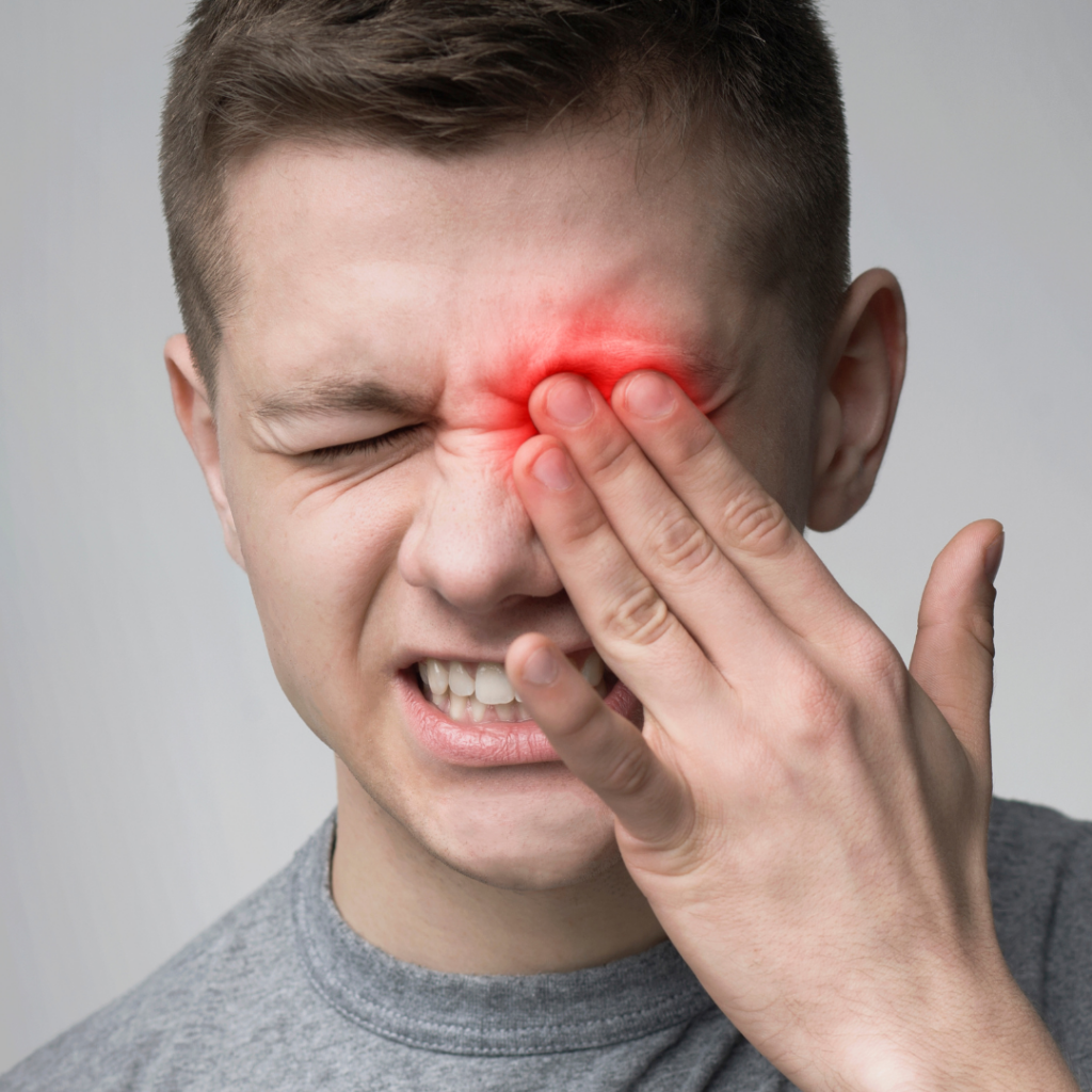 man rubbing eye suffering from discomfort due to eye symptoms
