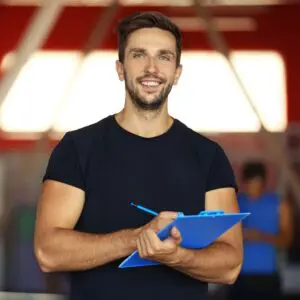 Centre for Sight man in gym with a blue clipboard and blue pen black t shirt and blue eyes stock image for blog post what are the benefits of laser eye surgery