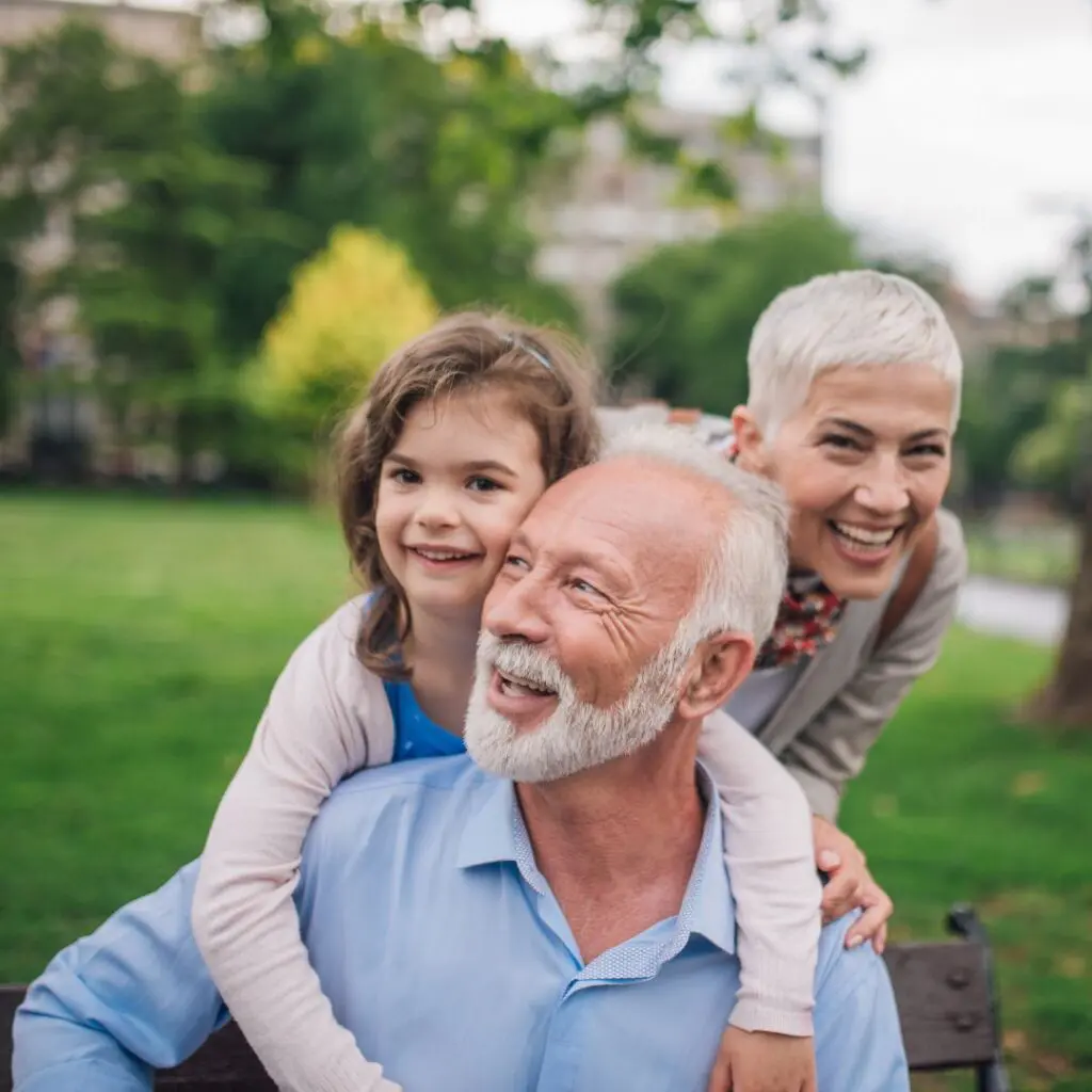 Centre for Sight image of family grandfather and grandmother with child hugging outside grey hair stock image for patient event