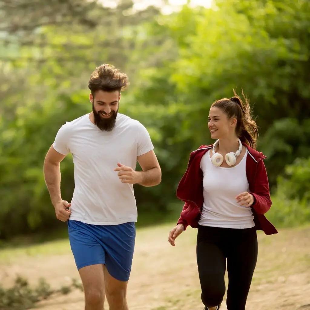 Centre for Sight couple running through woods wearing gym gear and headphones smiling laser eye surgery stock image for blog post can I have laser eye surgery with astigmatism