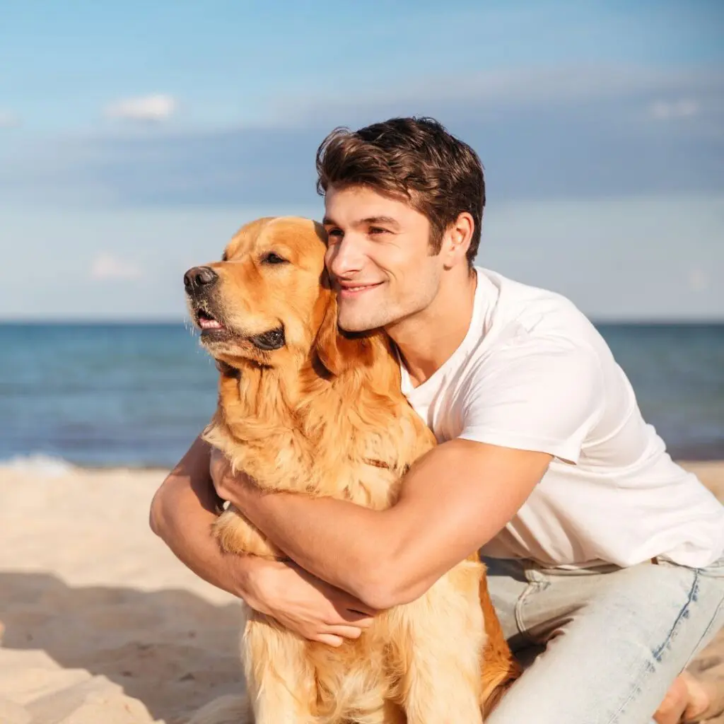 Centre for Sight man hugging dog on beach after laser eye surgery epsom