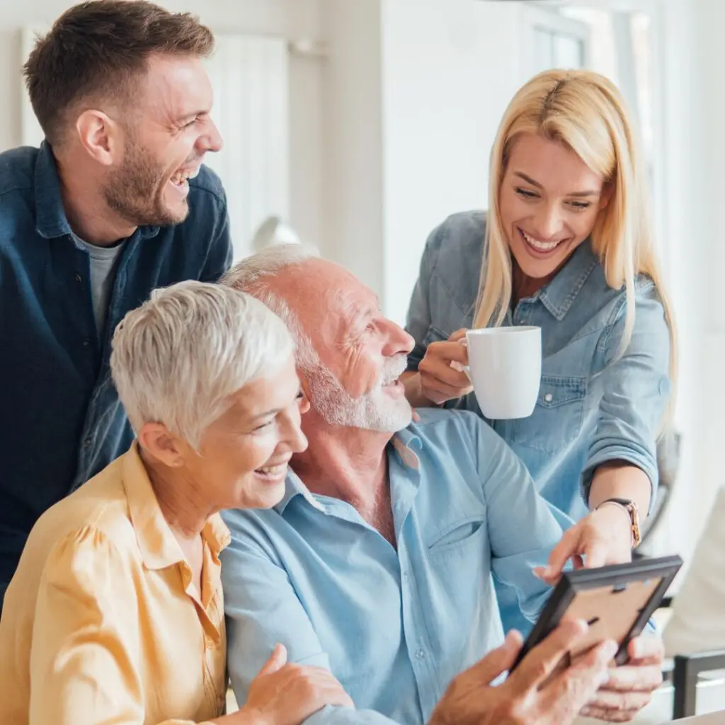 Centre for Sight family laughing looking at mobile phone after laser eye surgery horsham