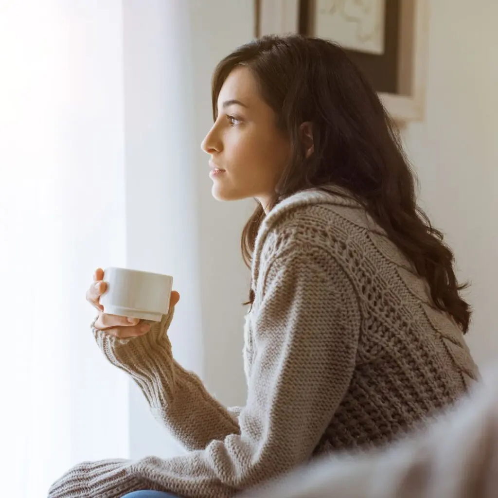 Centre for Sight lady holding tea looking out window after laser eye surgery