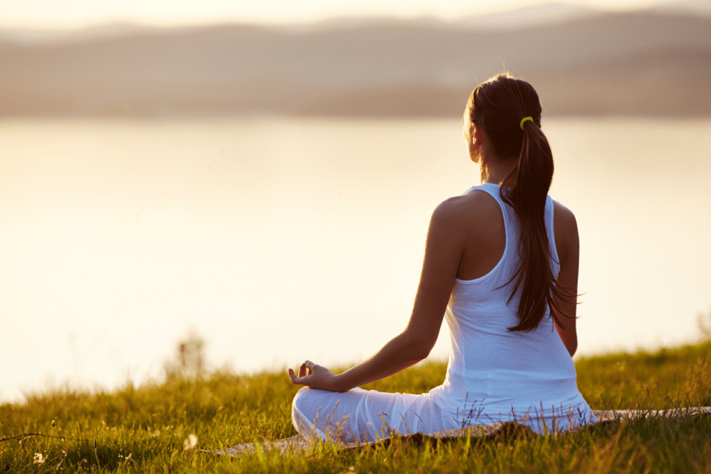 Young woman sat in the yoga position outdoors