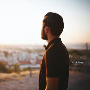 Man looking out at view in t shirt dark hair