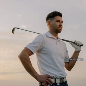Man planning golf with golf club over shoulder in white tea and sunset