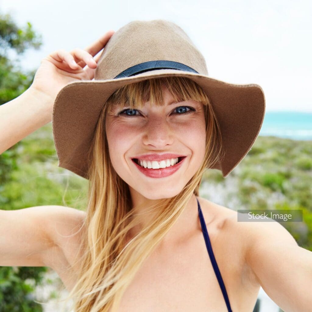 Centre for Sight patient story stock image lady in hat taking selfie in the sun on holiday straw hat