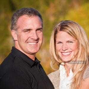 Middle aged couple standing outside together smiling at the camera