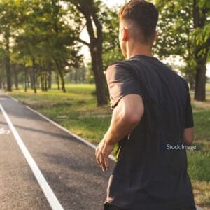 Young man running outside on track