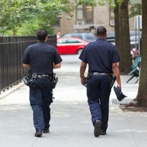 Two police officers walking down the streets of London in uniform