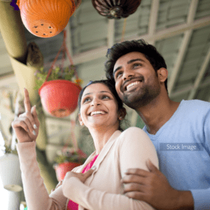 Young couple outside hugging wearing pink and pale blue smiling
