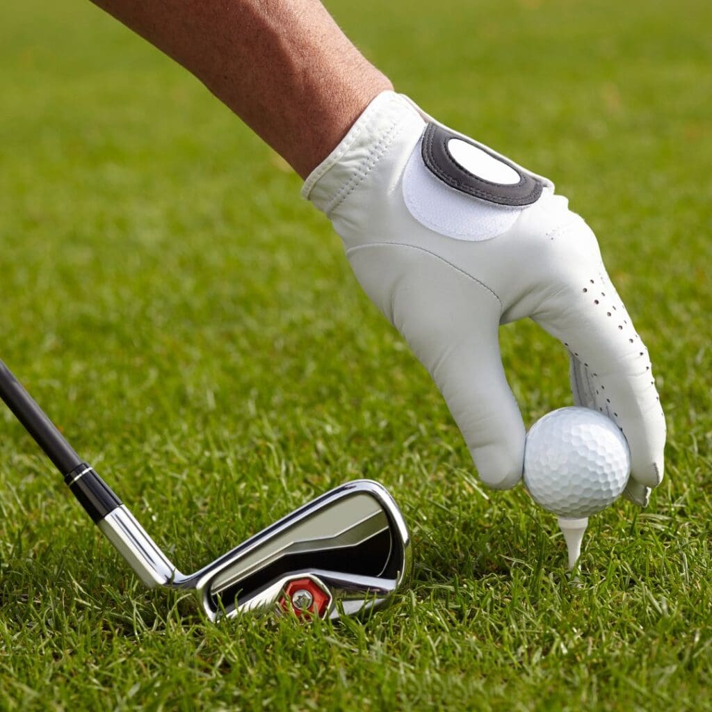 Centre for Sight man teeing up on golf course with glove on and club in the picture stock image