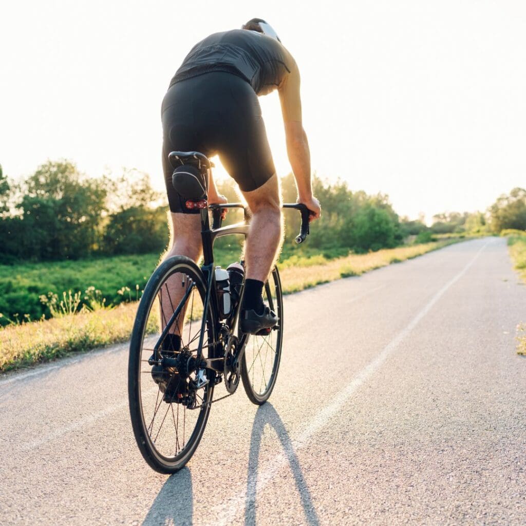 Centre for Sight man cycling on road bike along the road sun shining