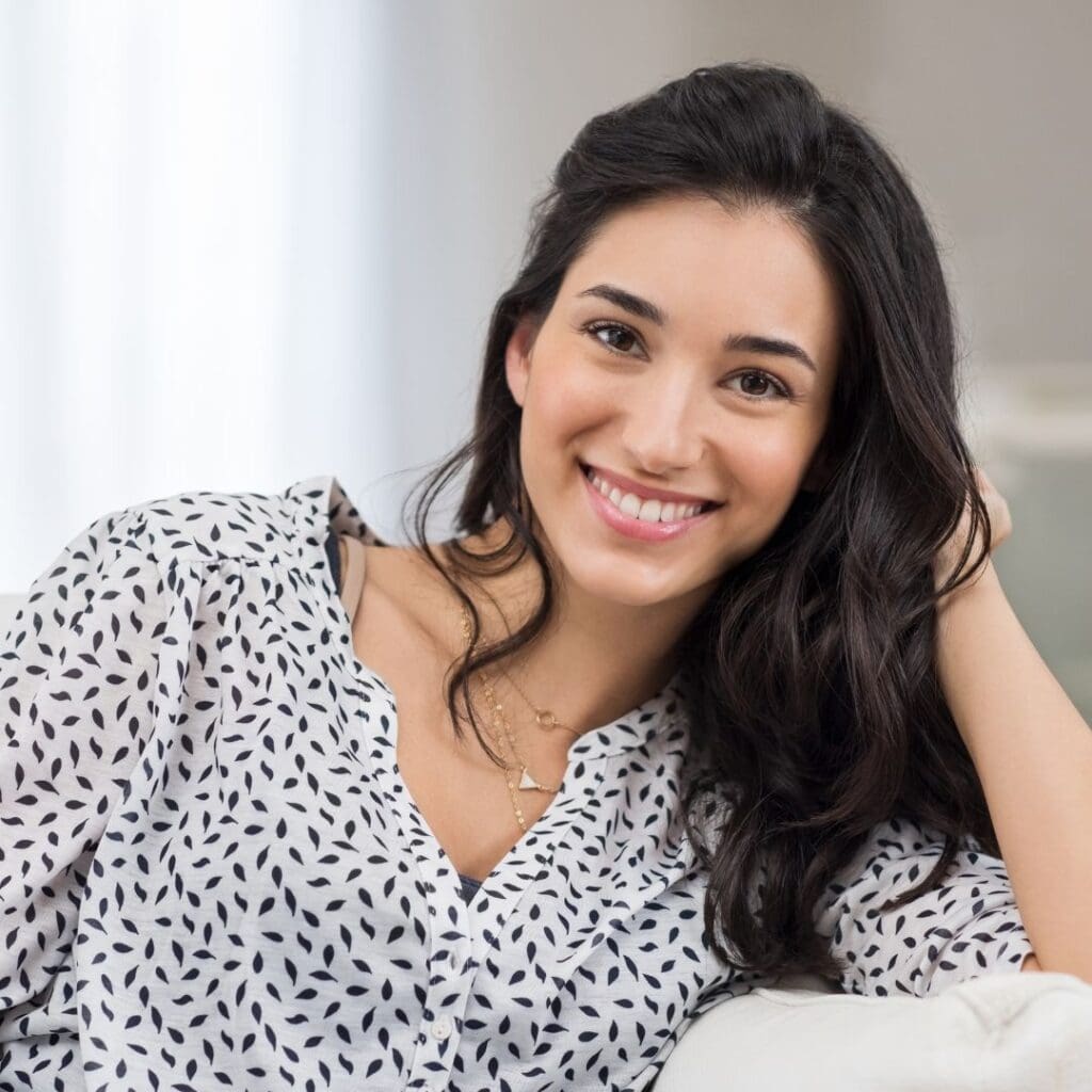 Centre for Sight young lady dark hair sitting on sofa smiling resting hand on head laser eye surgery blog stock image can I get laser eye surgery with astigmatism